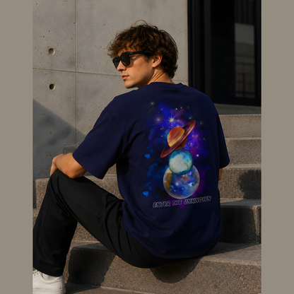 Person wearing a blue t-shirt with a space-themed design sitting on steps.